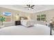 Light-filled primary bedroom features a tray ceiling, a fan, and lots of windows at 4993 Hook Hollow Cir, Orlando, FL 32837