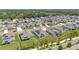 Aerial view of a well-maintained home with solar panels in a residential neighborhood with manicured lawns and tree-lined streets at 5220 Red Coral Cir, Mount Dora, FL 32757