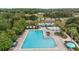 Aerial view of community pool, featuring umbrellas, lounge chairs, and a fountain, surrounded by landscaping at 5220 Red Coral Cir, Mount Dora, FL 32757