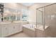 A bathroom with a tub, shower, and double vanity at 5220 Red Coral Cir, Mount Dora, FL 32757