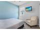 Comfortable bedroom with a cozy chair, a television, and a window allowing for lots of natural light at 5220 Red Coral Cir, Mount Dora, FL 32757