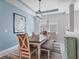 Charming dining room featuring stylish chairs, bench seating, modern light fixture and artwork, and large windows at 5220 Red Coral Cir, Mount Dora, FL 32757