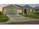 Charming one-story home featuring a two-car garage, lush lawn, and verdant landscaping at 5220 Red Coral Cir, Mount Dora, FL 32757
