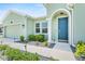 Inviting front entrance featuring a blue door, manicured landscaping, and a welcoming walkway at 5220 Red Coral Cir, Mount Dora, FL 32757
