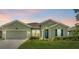 Charming single-story home featuring lush landscaping, a two-car garage, and a welcoming front door at 5220 Red Coral Cir, Mount Dora, FL 32757