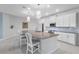 Well-lit kitchen featuring white cabinetry, gray countertops, and a spacious central island at 5220 Red Coral Cir, Mount Dora, FL 32757