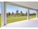 Covered patio area with bright white floor and pillars overlooking a large grassy backyard with black metal fencing at 5220 Red Coral Cir, Mount Dora, FL 32757