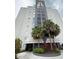 Modern building with palm trees and manicured landscaping offering a luxurious and inviting curb appeal at 6165 Carrier Dr # 1801, Orlando, FL 32819