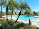 Resort-style pool surrounded by mature palms, landscaping, and plenty of lounge chairs at 6451 Old Park Ln # 407, Orlando, FL 32835