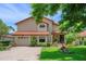 Charming two-story home featuring well-manicured landscaping, a brick driveway, and a welcoming front entrance at 6460 Parson Brown Dr, Orlando, FL 32819