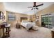 Spacious main bedroom with a ceiling fan, neutral carpet, and a sliding glass door to the back patio at 6460 Parson Brown Dr, Orlando, FL 32819