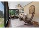 Charming screened porch featuring rocking chairs, ceiling fan, and views of the landscaped yard at 6460 Parson Brown Dr, Orlando, FL 32819