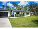 Well-manicured front lawn enhances the curb appeal of this cozy, light colored home at 655 N Arnold Ave, Groveland, FL 34736