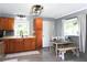 Bright eat-in kitchen features wooden cabinets, updated fixtures, and a cozy dining area with white chairs and bench at 655 N Arnold Ave, Groveland, FL 34736