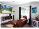 Comfortable living room features a recliner, media center with a large TV, and backyard view at 655 N Arnold Ave, Groveland, FL 34736
