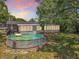 Backyard view with above-ground pool with a ladder, patio, and lawn, perfect for outdoor activities at 7375 Lake Dr, Sanford, FL 32771