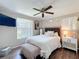 Stylish bedroom with a dark wood headboard, white bedding, and wood laminate flooring at 7375 Lake Dr, Sanford, FL 32771