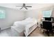 Bright bedroom with a ceiling fan, white bedding, and wood-look laminate flooring at 7375 Lake Dr, Sanford, FL 32771