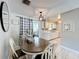 Sunlit dining area featuring a wooden table, stylish chairs, modern light fixtures, and an adjacent kitchen at 7375 Lake Dr, Sanford, FL 32771