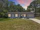 Charming single-story home with a well-maintained lawn, freshly painted exterior, and lovely curb appeal at sunset at 7375 Lake Dr, Sanford, FL 32771