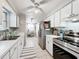 Bright kitchen features white cabinets, stainless steel appliances, modern fixtures, and an adjacent dining area at 7375 Lake Dr, Sanford, FL 32771