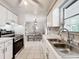 Kitchen featuring stainless steel sink, white cabinets, and view into the adjacent dining area with table and chairs at 7375 Lake Dr, Sanford, FL 32771