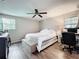 Comfortable main bedroom features a ceiling fan, hardwood floors, and a dedicated desk space at 7375 Lake Dr, Sanford, FL 32771