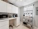 Bright pantry area with white cabinets, counter space, and a metal rack for storing kitchen essentials at 7375 Lake Dr, Sanford, FL 32771