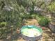 Aerial view of backyard pool with inflatable floats, surrounded by lush greenery and mature trees at 7375 Lake Dr, Sanford, FL 32771