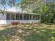 Exterior shot of sunroom with large windows and sliding doors providing a view of the well-maintained lawn at 7375 Lake Dr, Sanford, FL 32771