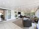 Inviting sunroom featuring tile flooring, string lights, and a sliding glass door at 7375 Lake Dr, Sanford, FL 32771