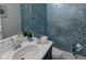 Stylish half bathroom with patterned wallpaper, modern sink and faucet, and decorative accents at 7550 John Hancock Dr, Winter Garden, FL 34787