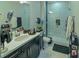 Modern bathroom with double sink vanity, a glass-enclosed shower, and ample storage at 7550 John Hancock Dr, Winter Garden, FL 34787