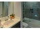 Clean bathroom featuring a single sink vanity, a shower-tub combo with glass doors, and neutral tones at 7550 John Hancock Dr, Winter Garden, FL 34787