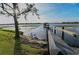 A wooden dock leads to a covered boathouse on the lake with a treed shoreline at 7550 John Hancock Dr, Winter Garden, FL 34787
