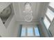 Stunning crystal chandelier in the foyer, complemented by high ceilings and natural light from the windows at 7550 John Hancock Dr, Winter Garden, FL 34787