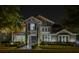 Night shot of a beautiful home featuring a stone facade, manicured landscaping, and a brick walkway at 7550 John Hancock Dr, Winter Garden, FL 34787
