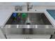 A stainless steel farmhouse sink with a modern faucet and accessories at 7550 John Hancock Dr, Winter Garden, FL 34787