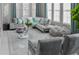 Bright living room with plush gray sofa, stylish pillows, large windows and plenty of natural light at 7550 John Hancock Dr, Winter Garden, FL 34787