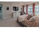Bright main bedroom with views of the pool and water with light wood floors and large dresser at 7550 John Hancock Dr, Winter Garden, FL 34787