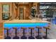 An outdoor kitchen shines with stone countertops, barstool seating, and modern appliances overlooking the backyard at 7550 John Hancock Dr, Winter Garden, FL 34787