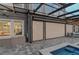 A stylish pool area with retractable screens, a built-in bench, and modern outdoor furniture at 7550 John Hancock Dr, Winter Garden, FL 34787