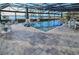 Inviting screened-in pool with an extended patio, lake view, and multiple seating and dining areas at 7550 John Hancock Dr, Winter Garden, FL 34787