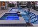 Relaxing screened-in pool with jacuzzi, lake view, extended patio, an outdoor kitchen, and lounge seating at 7550 John Hancock Dr, Winter Garden, FL 34787