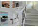 Bright staircase with white railings and black iron balusters overlooks the kitchen at 7550 John Hancock Dr, Winter Garden, FL 34787