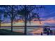 Scenic waterfront view of the property at sunset with trees in the foreground, showing natural beauty at 7550 John Hancock Dr, Winter Garden, FL 34787