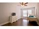 Bright bedroom offering hardwood floors, a single bed, a ceiling fan, and a television at 787 High Grove Park Ct, Oviedo, FL 32765