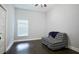 Neutral bedroom featuring dark wood floors, white walls, and a stylish black and white patterned loveseat at 787 High Grove Park Ct, Oviedo, FL 32765