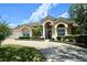 Lovely single-story home featuring a beautiful front lawn, arched entryway, and well-manicured landscaping at 787 High Grove Park Ct, Oviedo, FL 32765