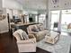 Comfortable living room open to kitchen features an island with bar seating, granite countertops, and hardwood floors at 787 High Grove Park Ct, Oviedo, FL 32765